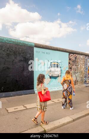 visitors at east side gallery, trabi breaking through wall Stock Photo