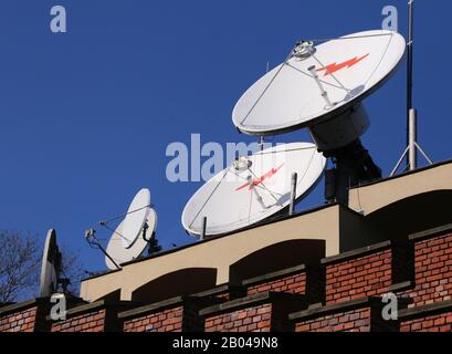 Cracow. Krakow. Poland. Satellite communications dish antennas on the rooftop against blue sky. Stock Photo