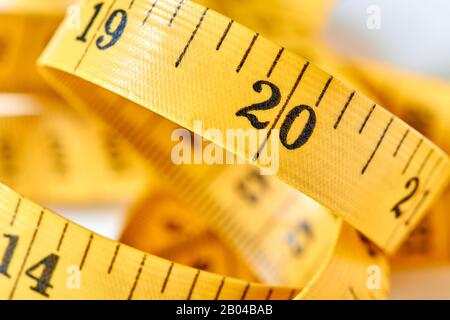 Yellow color centimeter with black figures for measurement of length and width on a white background. Measuring tape of the tailor for you design. Clo Stock Photo