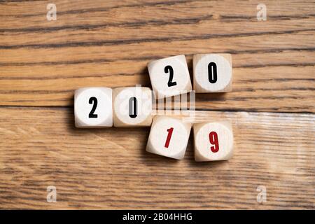cubes with numbers visualizing the change from 2019 to 2020 on wooden background Stock Photo