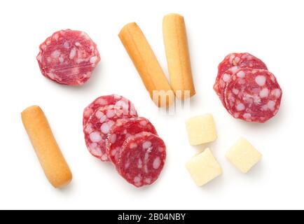 Salami slices, mini grissini breadsticks, hard cheese pieces isolated on white background. Italian appetizers. Flat lay. Top view Stock Photo