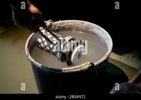 cooling hot cast mold in cold water after metal melting during jewellery production Stock Photo
