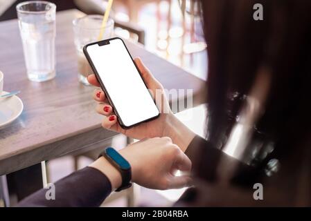 Smart phone mockup. Girl is looking at a smart bracelet. The concept of using health apps Stock Photo
