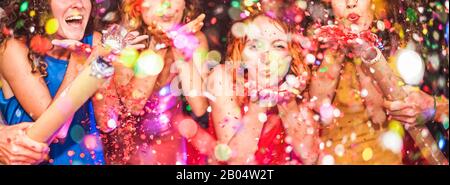 Young friends having party throwing confetti - Young people celebrating on weekend night - Entertainment, fun, new year's eve, nightlife, holidays, co Stock Photo