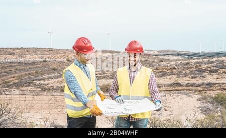 Workers engineers discussing renewable energy project - Builders planning how to build a new wind farm - Environmentally friendly, construction and sa Stock Photo