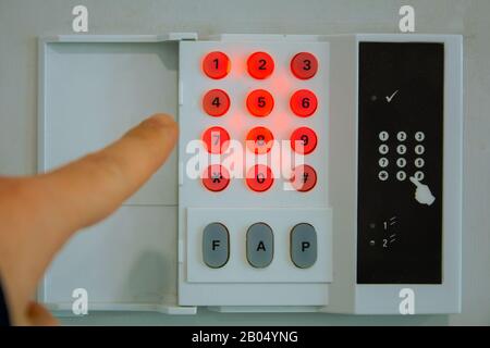 Close-up of a hand entering the door password on the wall Stock Photo