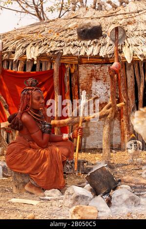 Himba woman cooking their traditional food made with wheat flour, Epupa Falls area, Kunene region, northern Namibia Stock Photo