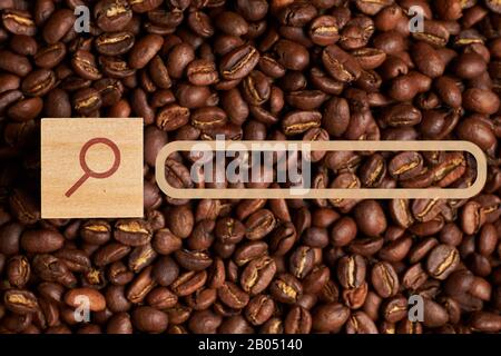 Abstract coffee search made from magnifier and coffee beans on background. Close up. Stock Photo
