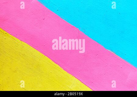 Abstract texture of plaster light blue and yellow with pink-colored line. Close up. Stock Photo