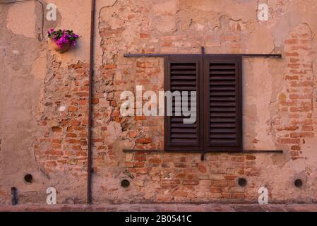 Vintage classic window on old brick wall with closed wooden shutters Stock Photo
