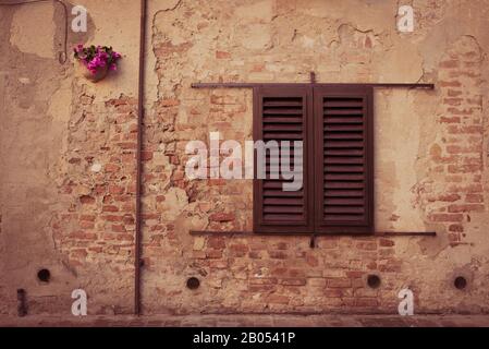 Vintage classic window on old brick wall with closed wooden shutters Stock Photo