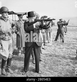 WINSTON CHURCHILL (1874-1965) firing a Thompson submachine gun alongside General Dwight Eisenhower  at right, during an inspection of American invasion forces in southern England in March 1944. Stock Photo