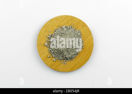 Close-up of a cosmetic dry green clay powder ion wooden round plate Stock Photo