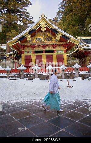 Japanese Shinto priest in traditional costume carrying a heavy bag down ...