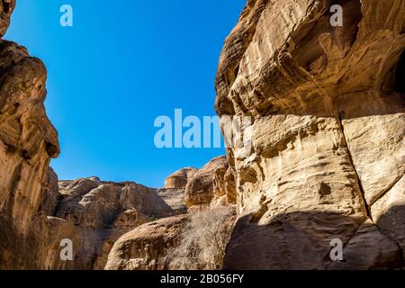 Breathtaking natural gorge called Al-Siq, carved in the red cliffs by the water flow, Petra ancient city complex and tourist attraction, Hashemite Kingdom of Jordan. Sunny winter day, cloudless sky Stock Photo