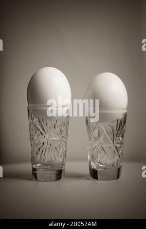 Two boiled chicken eggs peeled in a crystal glass on the table Stock Photo