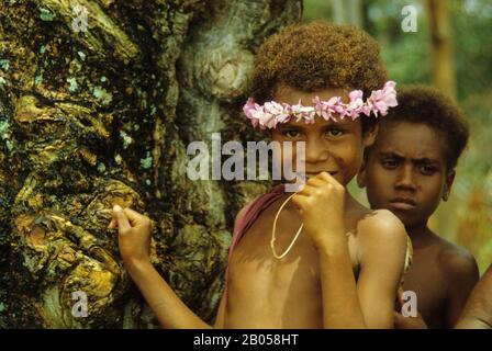 NEW GUINEA, TROBRIAND ISLANDS, PORTRAIT OF YOUNG GIRL WITH FLOWERBAND IN HAIR Stock Photo