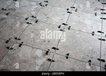 Plastic wedges and clips used for leveling ceramic tiles during installation of a floor. Stock Photo