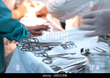 surgical instruments on a sterile table in the operating room. Surgeons work with hands Stock Photo
