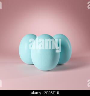 Three pastel turquoise colored easter eggs standing on a seamless pastel rose background. Copy space available.