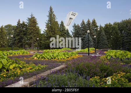 Raised stone borders with purple Angelonia angustifolia 'Serena Purple' - Summer Snapdragon, yellow Rudbeckia hirta 'Tiger Eye Gold - Black-eyed Susan Stock Photo