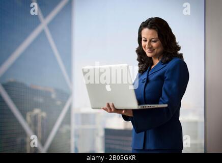 Smiling middle aged businesswoman using a laptop computer. Stock Photo