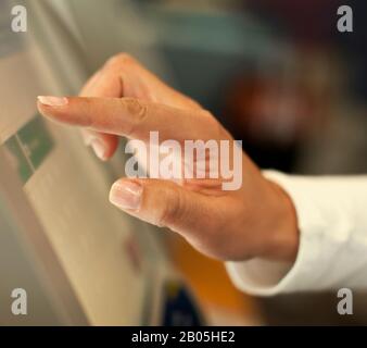 Hand of a mid adult man using a touch screen. Stock Photo