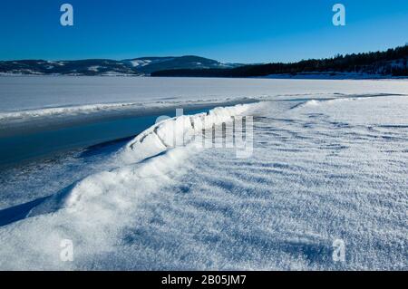 Crack in the ice formation on the edge of the lake Stock Photo