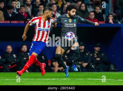 Liverpool's FC Mohamed Salah and Atletico de Madrid's Renan Lodi  are seen in action during the UEFA Champions League match, round of 16 first leg between Atletico de  Madrid and Liverpool FC at Wanda Metropolitano Stadium in Madrid.(Final score; Atletico de Madrid 1:0 Liverpool FC) Stock Photo