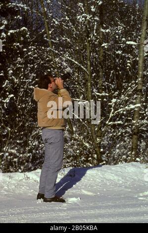 USA, WASHINGTON STATE, BELLEVUE, MAN TAKING PHOTOS IN THE SNOW Stock Photo