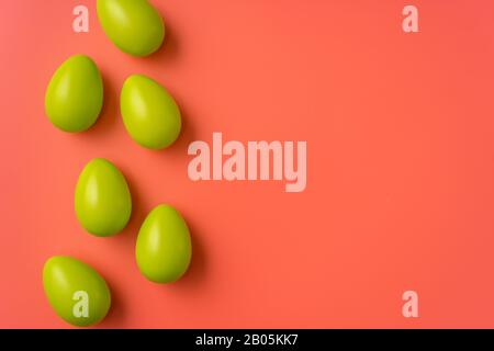 Easter concept. Simple composition with green eggs on vibrant orange background Stock Photo