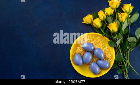 Phantom blue color and yellow roses with Easte eggs on vintage background Stock Photo