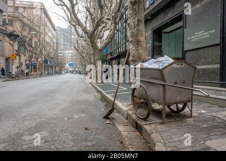 A trash collection cart on the sidewalk of an empty street , Shanghai, China Stock Photo