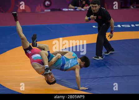 New Delhi, India. 18th Feb, 2020. Pouya Mohammad Naserpour of Iran (L) vies with Jasurbek Ortikboev of Uzbekistan during the men's 55kg Greco-Roman wrestling final match at the Asian Wrestling Championships 2020 in New Delhi, India, Feb. 18, 2020. Credit: Javed Dar/Xinhua/Alamy Live News Stock Photo