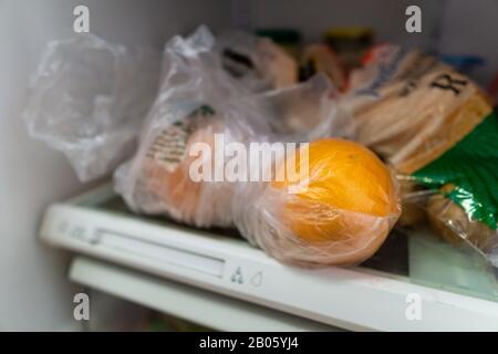 Oranges in a plastic bag in fridge Stock Photo