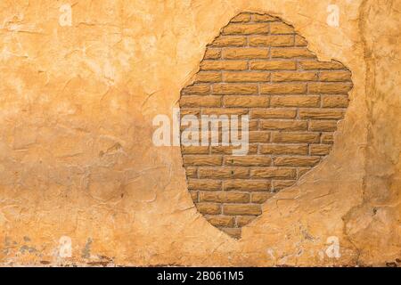 Brick behind Lathe Stucco Wall in Brown and Beige colors from Old Building Stock Photo