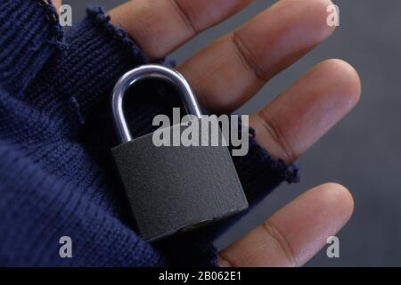 close up of padlock on hacker hand with gloves  Stock Photo