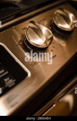 Stainless steel front burner knob of a stove close up Stock Photo