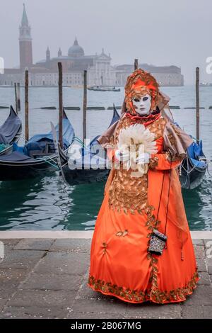 A mask poses in St. Mark's Square on February 17, 2020 in Venice, Italy. The theme for the 2020 edition of Venice Carnival is ‘Game, Love & Folly' Stock Photo