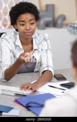 female architect studying plans in open plan office Stock Photo