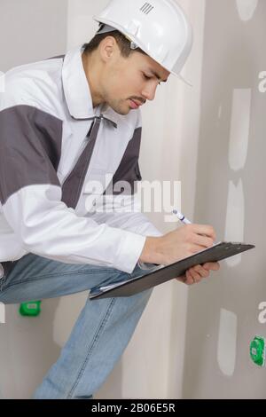 builder writting on a clipboard Stock Photo
