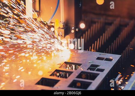 Industrial Laser cutting processing manufacture technology of flat sheet metal steel material with sparks Stock Photo