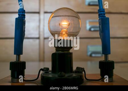 Glowing traditional Tungsten light bulb in physics class Stock Photo