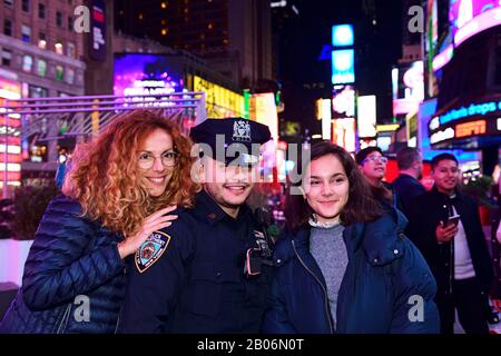 Policeman has his picture taken with tourists in Times Square, Manhattan, New York City, New York State, USA Stock Photo