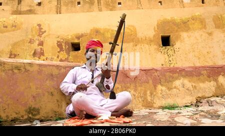 Rajasthani man playing music in Amer fort in jaipur, Rajasthan Stock Photo
