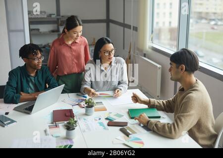 Young business leader talking to his business team and they listening to him attentively during meeting at office Stock Photo
