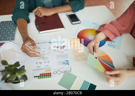 Close-up of business people sitting at the examining business graphics in team and working with colored pattern Stock Photo