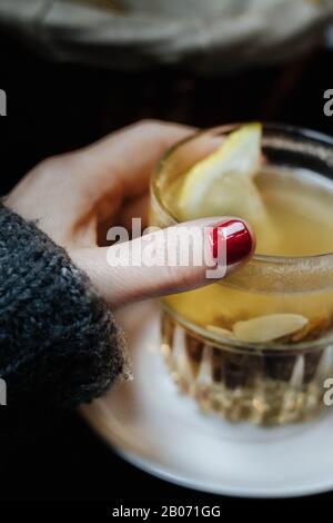 a glas of water with lemon in womans hand Stock Photo