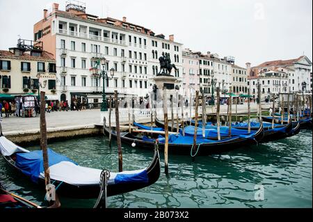 City of Venice, Italy, Europe. Gondolas moored alongside Grand Canal with blue covers.  Hotels on Grand Canal in background Stock Photo