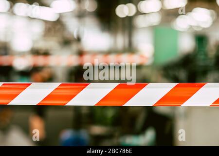 danger unsafety area caution do not enter red stripe tape with industry factory background. Stock Photo